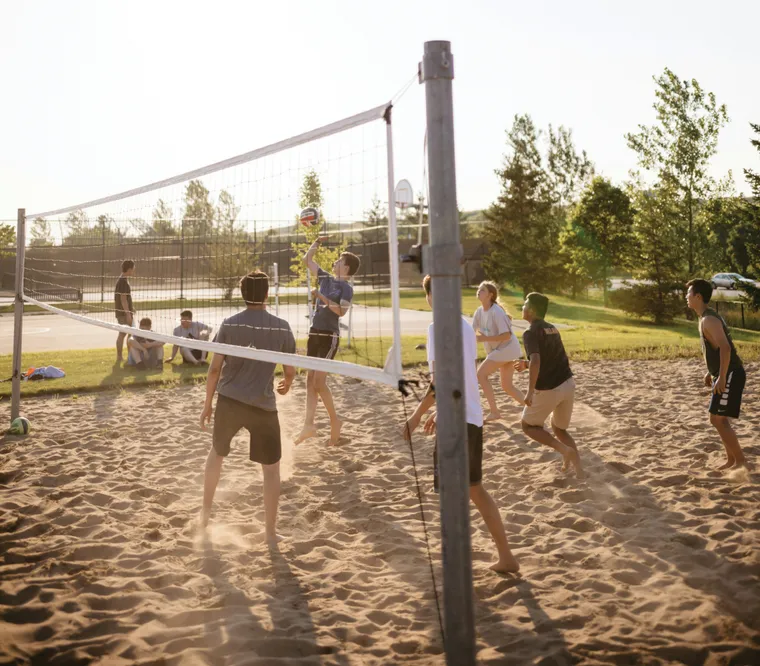 A group of friends playing sand volleyball